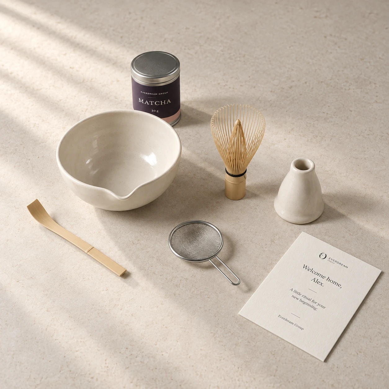 Ceramic bowl, bamboo tools, steel sifter, matcha tin and personal card arranged outside their gift box